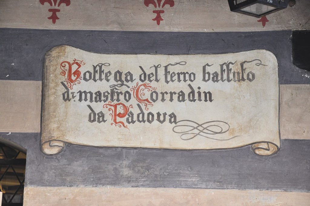 Decorazione pittorica che indica la "Bottega del ferro battuto di mastro Corradin da Padova"